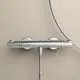 Brausethermostat aus verchromtem Material, von Ideal Standard, montiert an einer hellen Wand. Die steuerbaren Knöpfe sind an der Oberseite sichtbar.